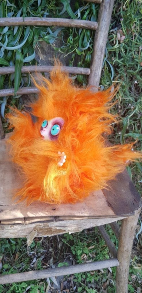 Peluche MicioMicio il Folletto che si traveste da gatto arancione con occhi azzurri